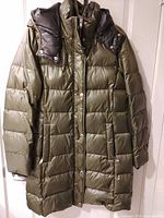 Front view of olive quilted puffer coat hanging