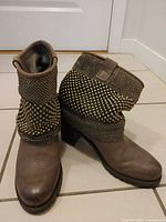 Full view of both boots showing studded cuffs, overall design and color