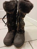 Front view of boots upright showing faux-fur cuffs, laces, toe shape