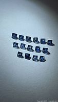 Group of fifteen square blue sapphires on neutral background