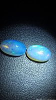 Both opal cabochons showing body tone and play-of-colour