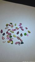 Group view of mixed-color leaf-cut tourmaline gemstones on white background