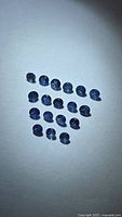 Group of 19 round blue sapphires on white background