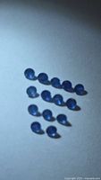 Loose round blue sapphires arranged on neutral background