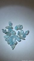 Group of light blue zircon crystal pieces on white background