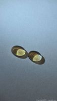 Two golden citrine cabochons side-by-side on neutral background