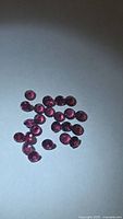 Group of small round faceted garnets on white background