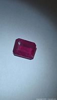 Rectangular emerald-cut ruby on light background
