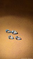 Four pear cut aquamarines on brown surface