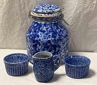 All four spongeware pieces grouped: canister, creamer, two ramekins