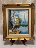 Full view of framed painting on easel