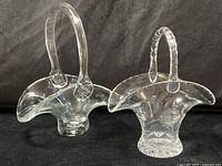 Both clear glass baskets, showing overall shapes and handles