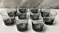 Ten smoky gray tumblers grouped