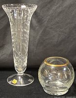 Tall fluted crystal vase and round gold-rimmed vase side by side