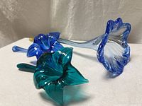 Blue and teal glass flowers angled to show color and petal detail