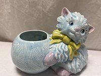 Side view of planter showing cat and yarn ball opening
