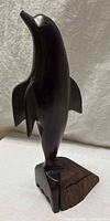 Full view of entire ironwood dolphin sculpture on base