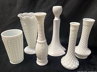 All six milk glass vases front view on black backdrop