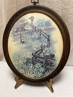 Front view of oval wall plaque showing full rustic cabin scene and wood frame