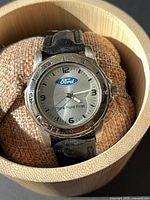 Front view of Ford wristwatch on cushion showing dial and bezel