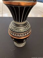 Full view of vase showing flared rim, neck, and Greek key pattern
