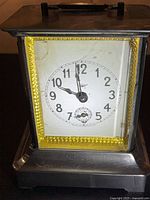 Front view of Kienzle musical alarm clock showing full case and dial