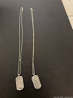 Two meteorite dog tag necklaces full view