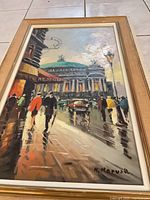 Full view of framed painting showing street scene and dome building