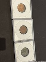 Three coins stacked in individual holders