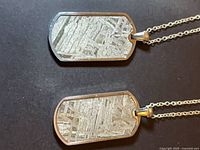 Two meteorite dog tag necklaces side by side