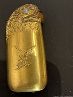 Front view of eagle head lighter showing opal eye and engraved eagle emblem