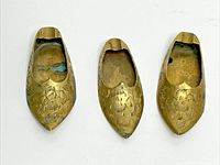 Top view of three brass slipper ashtrays