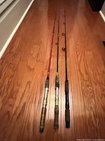 Three fishing rods laid side-by-side showing full length and handles