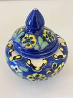 Ginger jar with lid on, showing floral decoration and pointed finial