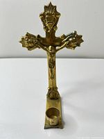 Front view of brass crucifix with candle holder