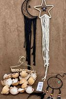 Group shot showing crescent moon dream catcher, star wall hanging, shell wind chime and small round dream catcher