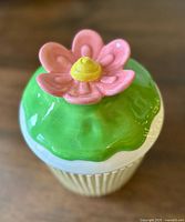 Top view of cookie jar showing green icing and pink flower handle