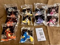 Group shot of 11 sealed plush toys showing variety of characters and duplicated items