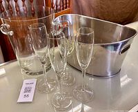 Group shot of four champagne flutes, glass ice bucket, stainless cooler