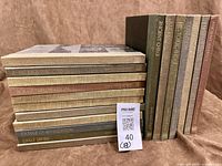 Full lot showing 18 hardcover books in two stacks