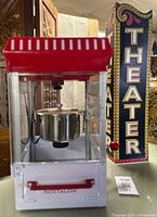 Front view of Nostalgia popcorn maker and theater sign