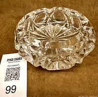 Overall ashtray showing faceted walls, scalloped rim, starburst base, retail sticker visible