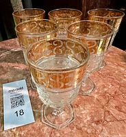 All six goblets clustered showing gold rims and pressed pattern