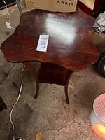 Full view of mahogany parlor table showing scalloped top, lower shelf and cabriole legs