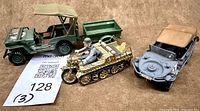 Three plastic military vehicle models with trailer and driver figure displayed together