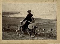 full image of photograph showing man and child on motorcycle