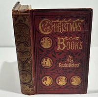 Front view of red cloth gilt-decorated hardcover showing title Christmas Books By Charles Dickens