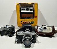 Group shot showing all four cameras and Kodak box