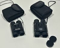 Both binoculars with cases and lens cap displayed