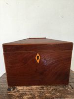 Front view of wooden tea caddy showing keyhole escutcheon